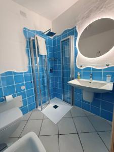 a blue bathroom with a sink and a mirror at Residence Isola dei Mori in SantʼAntìoco +90 photos