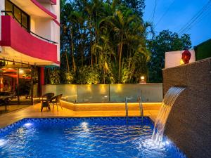 a swimming pool with a fountain in a building at Girivihar Holiday Club - Pure Veg in Lonavala