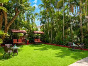 a green yard with chairs and tables and trees at Girivihar Holiday Club - Pure Veg in Lonavala