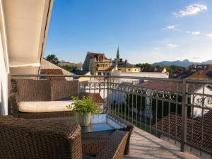 a balcony with two chairs and a glass table at Bad Aibling City Apartment - Pano in Bad Aibling