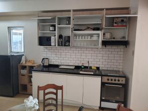 a kitchen with white cabinets and a black counter top at RPCB Condo Rental in Cagayan de Oro