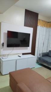 a living room with a flat screen tv on a wall at RPCB Condo Rental in Cagayan de Oro