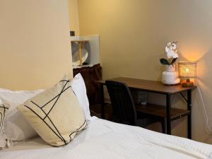 a bedroom with a bed and a table with a vase of flowers at Bahay El Nido in El Nido