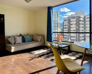 a living room with a couch and a large window at Amplia suite cerca a La Carolina - Av 6 Diciembre in Quito