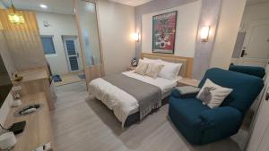 a bedroom with a bed and a blue chair at 和光寓所-自助加Line取密碼 in Hung-i-li