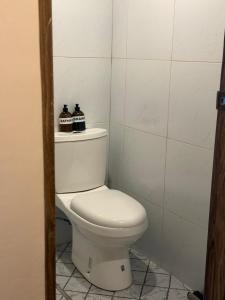 a bathroom with a toilet with two bottles on it at Bahay El Nido in El Nido