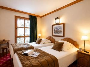 a hotel room with two beds and a window at Résidence Les Sources de Marie - ARCS 1950 in Arc 1950