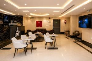 a restaurant with white chairs and tables and a couch at فندق إتقان المشاعر in Mecca