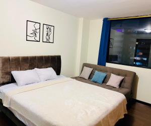 a bed and a couch in a room at Amplia suite cerca a La Carolina - Av 6 Diciembre in Quito