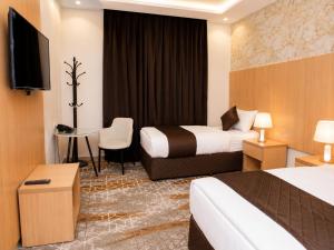 a hotel room with two beds and a television at فندق إتقان المشاعر in Mecca +23 photos