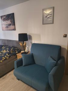 a blue couch in a living room with a bed at Przy Żelaznym Moście in Kłodzko