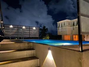 a swimming pool at night with a building at Villa Shakthi in Pondicherry