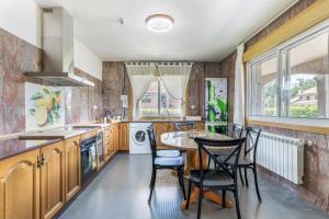 a kitchen with a table and chairs and a sink at Os Cabaleiros in Mos