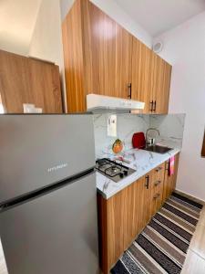 a kitchen with a stainless steel refrigerator and wooden cabinets at Villa Kalaj in Baks-Rrjoll +22 photos