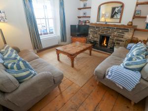 a living room with two couches and a fireplace at 1 Dormer Villas in Porthscatho