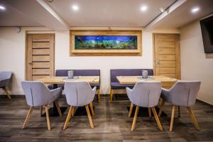 a conference room with tables and chairs and a fishtank at Apartmány Superior Vila Věra in Rožnov pod Radhoštěm
