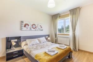 a bedroom with a bed with two towels on it at Os Cabaleiros in Mos