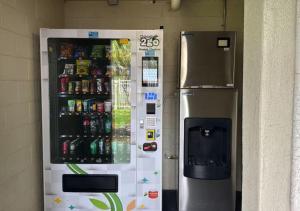 a vending machine with drinks in it next to a refrigerator at Lyrios Vacation Rentals - Legacy in Kissimmee