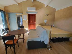 a room with a bed and a table and a table and chairs at La Maisonnette Veyronne - Gîte neuf in Aubres