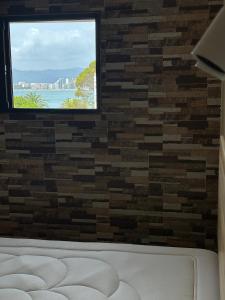 a room with a brick wall and a window at Isla de los Pensamientos in Cullera
