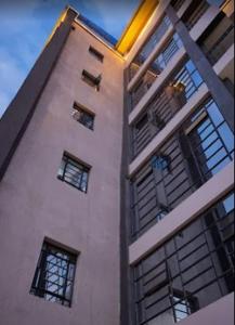 a tall white building with windows at Happy Homes Airbnbs- Kikuyu in Nairobi