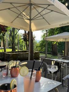 a table with an umbrella and some drinks on it at Pousada Torre Lombarda in Allariz