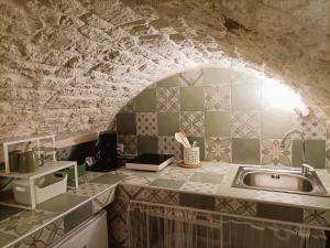 a kitchen with a sink and a stone wall at La Carruba in Ceglie Messapica +20 photos