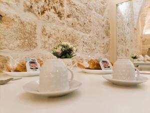 a table with cups and plates of food on it at La Carruba in Ceglie Messapica