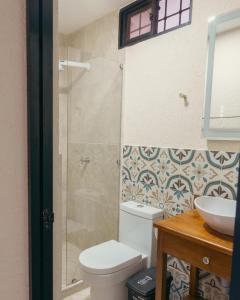 a bathroom with a shower and a toilet and a sink at Hotel La Casona Del Valle in Valledupar