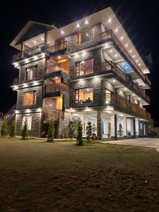 a tall building with lights on it at night at Shalom Hillcrest Inn in Shimla