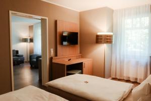 a hotel room with a bed and a mirror at Schlossberghotel Greiz in Greiz
