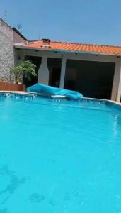 a large blue swimming pool in front of a house at Suíte Excellence - 01 in Pirenópolis