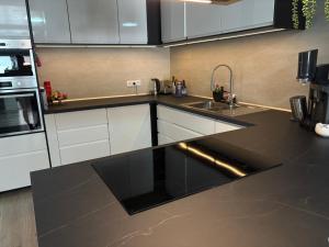 a kitchen with white cabinets and a black counter top at Rhythm & Rest in Boom +7 photos
