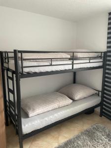 a black bunk bed with two pillows on it at Mng home in Kippenheim