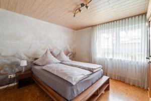 a bedroom with a bed and a large window at Ferienwohnung Waldrose in Oberharmersbach