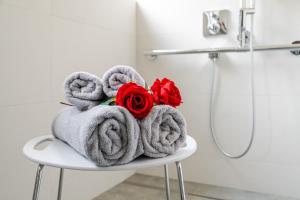 a pile of towels and roses on a table in a bathroom at Ferienwohnung Waldrose in Oberharmersbach +29 photos