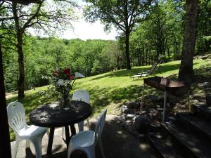 a patio with a table and chairs and a grill at Gîte d'Alithe in Montamel