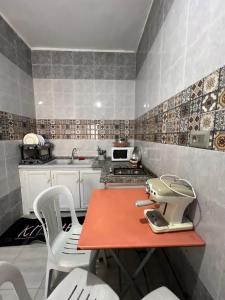a kitchen with a red table and white chairs at Djerba Appartement in Houmt Souk +24 photos