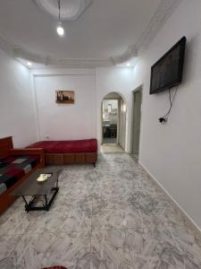 a living room with a couch and a tv on the wall at Djerba Appartement in Houmt Souk