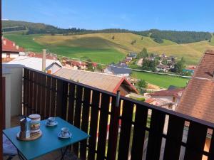 a balcony with a table with two cups of coffee at Chalet Iris in Bertigo
