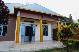 a small house with yellow columns at Chez Kivu in Rubavu