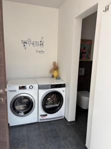 a washing machine and a washer in a bathroom at Rhythm & Rest in Boom