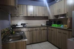 a kitchen with wooden cabinets and a sink at Chez Kivu in Rubavu