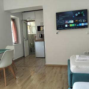a living room with a table and a tv on a wall at Kostaki spila apartment in Himare