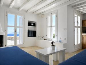 a white room with a bed and a table at Folegandros Villas Aspropounta Double Room Beachfront in Chora Folegandros