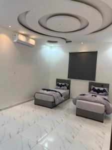 a living room with two beds and a screen at شقه ارضيه in Hail