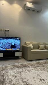 a living room with a couch and a flat screen tv at شقه ارضيه in Hail
