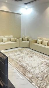 a living room with white couches and a rug at شقه ارضيه in Hail +2 photos