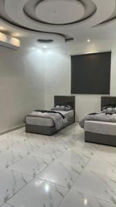 a bedroom with two beds and a projection screen at شقه ارضيه in Hail
