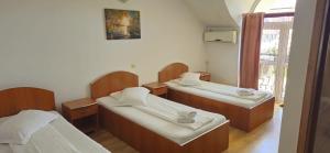 a room with three beds and a window at Hotel Casa Traiana in Alba Iulia